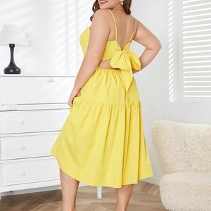 Detail of yellow backless maxi dress featuring a large bow and adjustable straps
