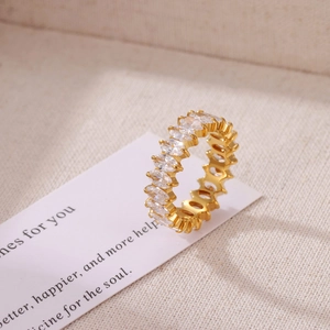 Elegant gold eternity ring with marquise-cut zircon stones on a decorative background