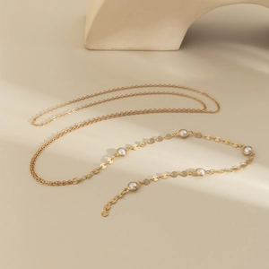 Dettaglio ravvicinato della collana d'oro con dischi di metallo lucido e perle eleganti