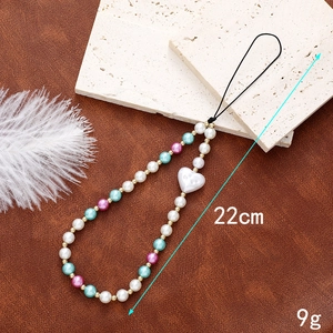 Detail of 22cm handmade phone strap with pearls and heart charm weighing 9g