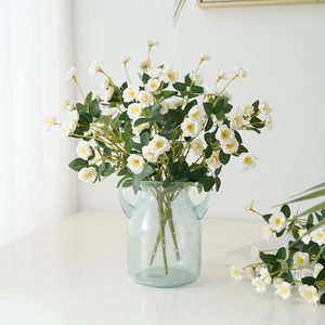 Artificial white roses in a light blue glass vase for home decor and photography