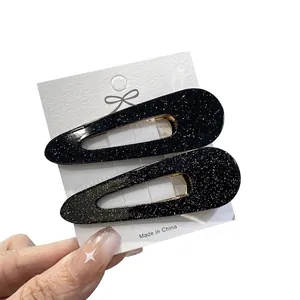 Two-pack of black glitter teardrop hair clips on a card for women's hairstyling