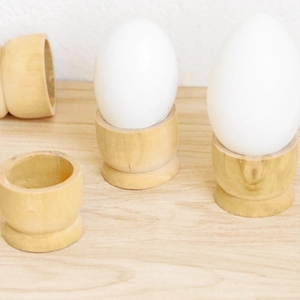 Set of four minimalist wooden egg holders in a classic goblet shape for home decor