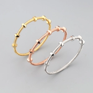 Industrial screw nut bracelets in gold, silver and rose gold finishes on grey background