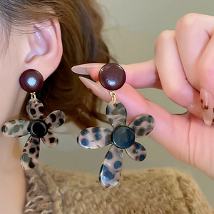 Close-up of vintage flower earrings featuring brown leopard print acetate petals