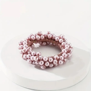 Detailed view of handmade lilac pink pearl elastic hair tie on a white podium