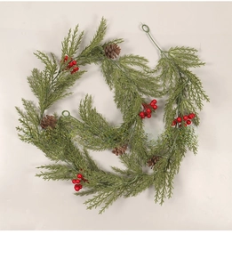 Macro detail of artificial pine garland with red berries and small brown pinecones