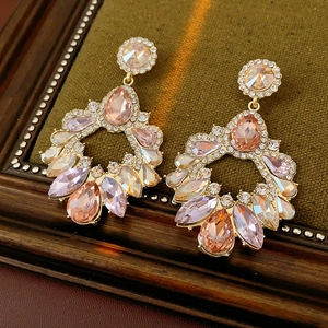 Boucles d'oreilles lustres dorées avec strass roses et transparents sur velours vert