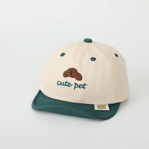 Close-up of cute puppy embroidery and woven label on a beige cotton toddler baseball cap