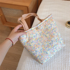 Close-up of floral lunch bag with daisy patterns and antique bronze snap button
