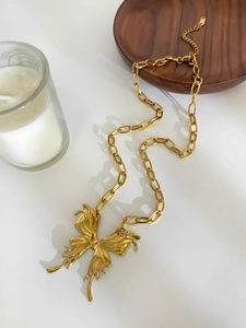 Macro shot of liquid metal butterfly pendant on thick link chain with lobster clasp