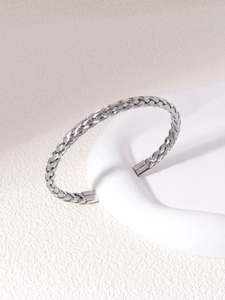 Detailed close-up of handmade twisted texture on stainless steel cuff bracelet