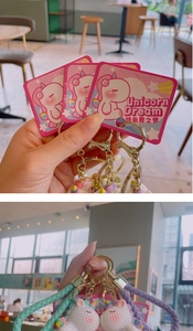 Detail view of colorful PVC unicorn keychain with braided lanyard and metal keyring