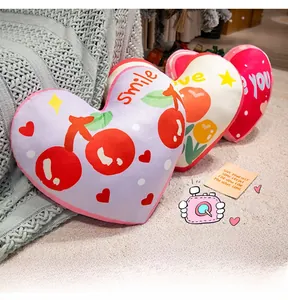 Close-up of heart-shaped plush pillows with cherry patterns and soft velvet texture