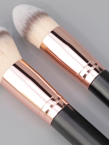 Detail of dual-ended makeup brushes with rose gold ferrules and soft synthetic bristles