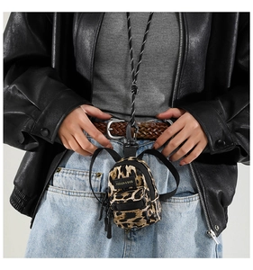 Detail of mini leopard print shoulder bag with adjustable lanyard shown on model