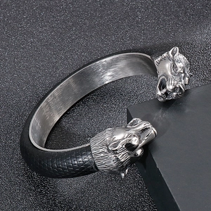 Macro detail of punk style leopard head buckle with black scale texture on metal bracelet