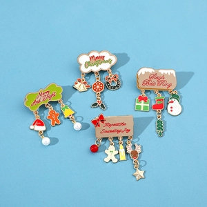 Detail showing four festive enamel Christmas brooches with hanging charms on blue backdrop