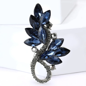Detail view of leaf-shaped brooch with deep blue crystals and silver rhinestone accents