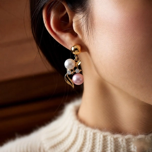 Close-up of vintage flower earrings with white pearls and pink crystals on model