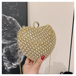Close-up of golden heart-shaped rhinestone evening bag with delicate metal chain