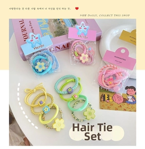 Flat lay of colorful macaron flower hair ties and bunny elastic bands set on a white desk