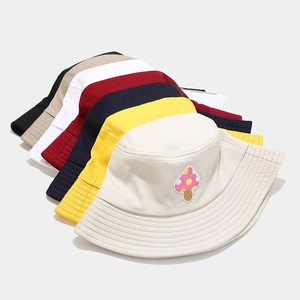 Close-up of canvas bucket hats in multiple colors featuring mushroom embroidery patches