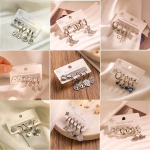 Detailed macro view of 9 sets of stainless steel earrings with celestial and nature motifs