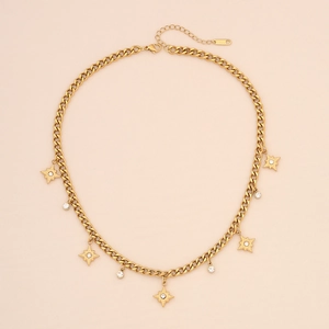 Détails d'un collier chaîne cubaine en acier doré avec breloques étoile et strass