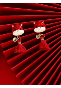 Detailed macro view of Chinese New Year red enamel horse earrings with long tassels
