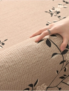 Detailed texture of beige carpet with black floral patterns and soft tactile hand feel