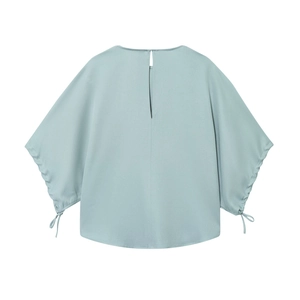 Detail view of light blue shirt back featuring puff sleeves with drawstring bow details