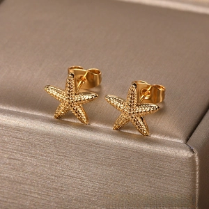 Detailed macro view of golden starfish stud earrings with fine textured metallic finish
