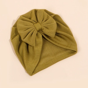 Détail du bonnet turban côtelé jaune moutarde pour bébé avec un grand nœud décoratif