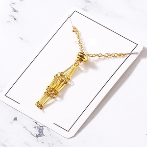 Detailed shot of golden geometric tassel necklace on white card with marble backdrop