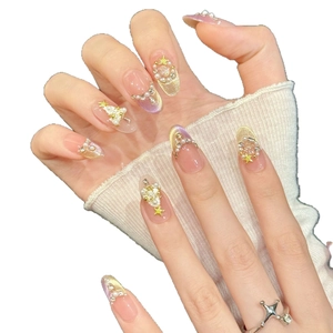 Unghie finte sfumate rosa con perle, strass e stelle dorate per un look festivo
