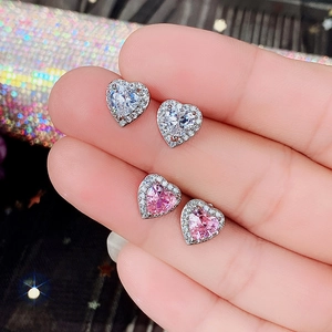 Detailed close-up of heart-shaped zircon earrings in pink and clear white crystal sets