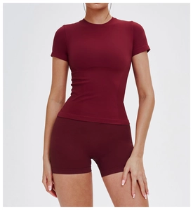 Dettaglio del tessuto elasticizzato senza cuciture bordeaux su top yoga e pantaloncini
