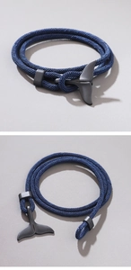 Detail showing blue multilayer braided rope bracelet with black whale tail metal clasp