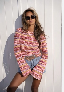 Détail du motif ondulé rétro coloré et de la texture au crochet sur le haut à manches évasées