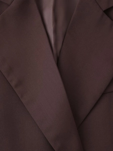 Close-up of lapel and woven texture on dark brown tailored blazer for women