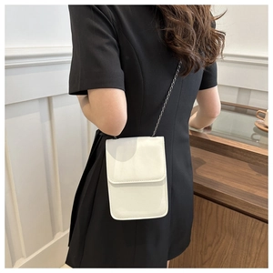 Detail of white minimalist mobile phone crossbody bag with fine PU texture and metal chain