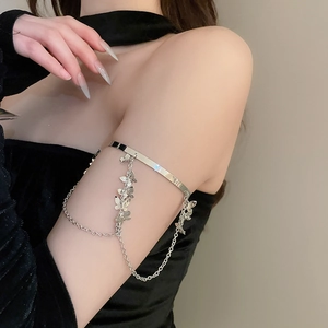 Detail of silver butterfly tassel upper arm cuff with hanging metal chains and pendants
