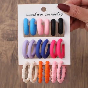 Détail de 9 paires de boucles d'oreilles acryliques avec formes C et ondulées