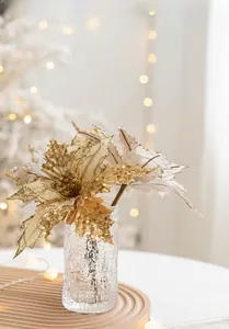 Golden artificial poinsettia with sequins in a glass vase for Christmas tree decoration