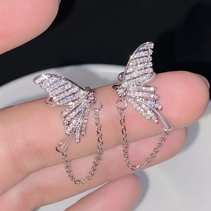 Detail of silver butterfly ear cuff with sparkling rhinestones and delicate metal chains