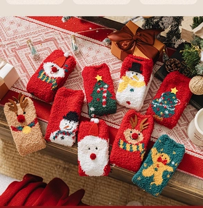 Detailed view of plush coral fleece Christmas socks with embroidered Santa and reindeer patterns