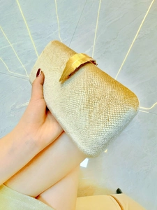 Champagne gold evening clutch bag with metal leaf clasp and pearlescent textured finish