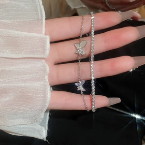 Detail of silver butterfly charm bracelets featuring delicate cubic zirconia pave settings