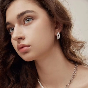 Elegant silver pearl earrings and layered necklace set shown on a female model